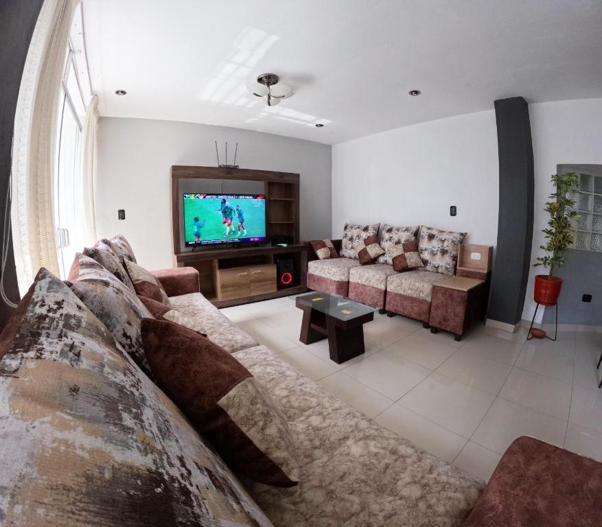 sala de estar con sofá y TV en Departamento amplio y bonito en Arequipa, en Arequipa