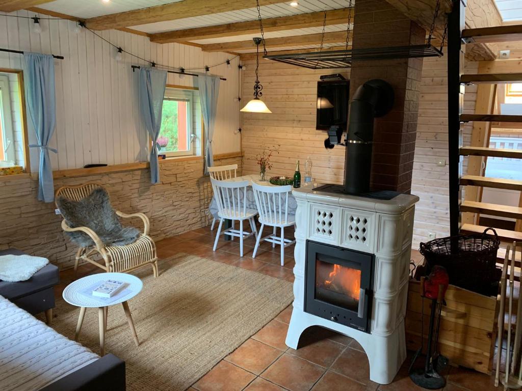 a living room with a stove and a table at Hygge chaloupka v horách in Český Jiřetín