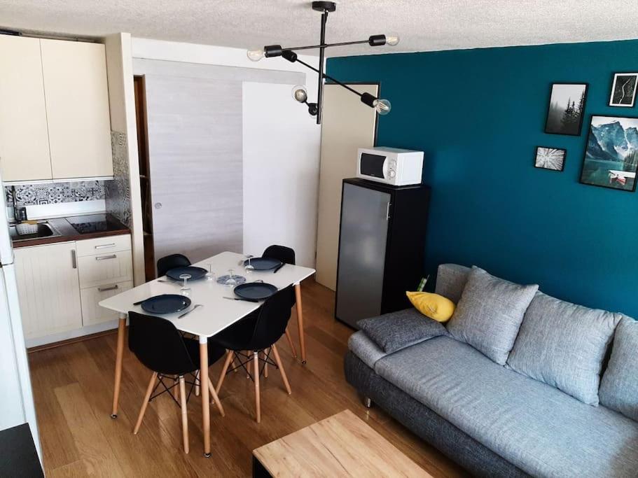 a living room with a table and a couch at Saint lary soulan village T2 Avec parking in Saint-Lary-Soulan