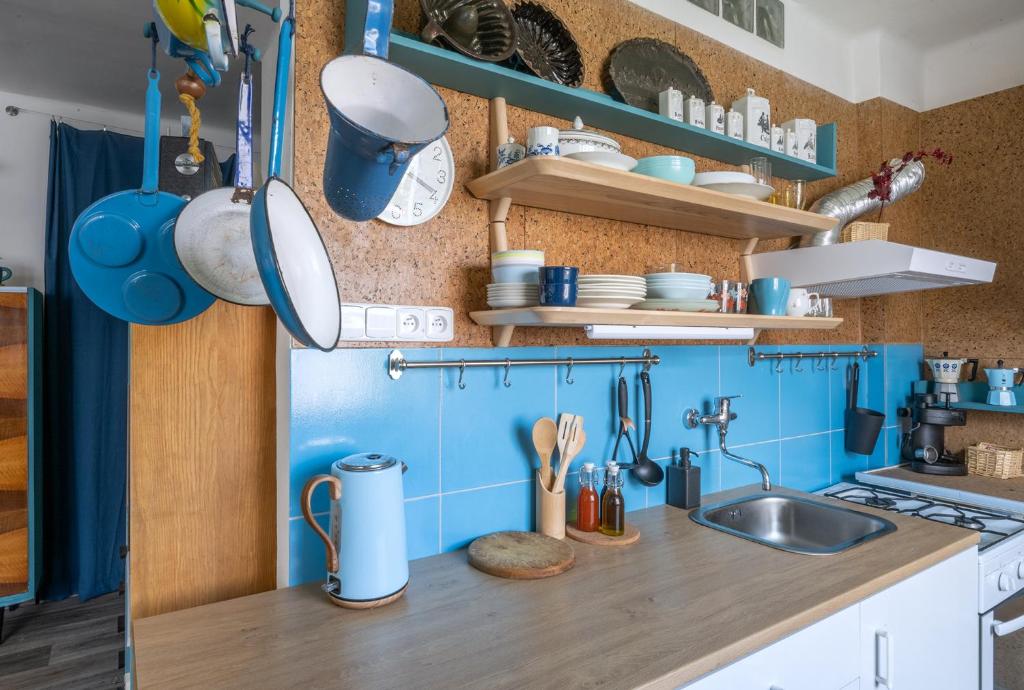 a kitchen with blue tiles and a sink at Retro Art room in Lomnice nad Popelkou