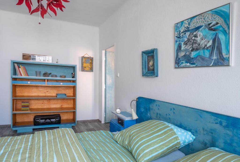 a bedroom with a bed and a book shelf at Retro Art room in Lomnice nad Popelkou
