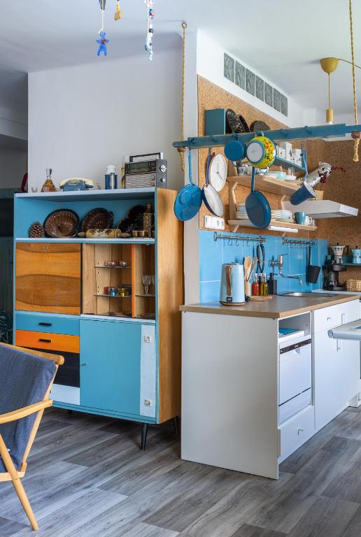 a kitchen with blue and white cabinets and a table at Retro Art room in Lomnice nad Popelkou