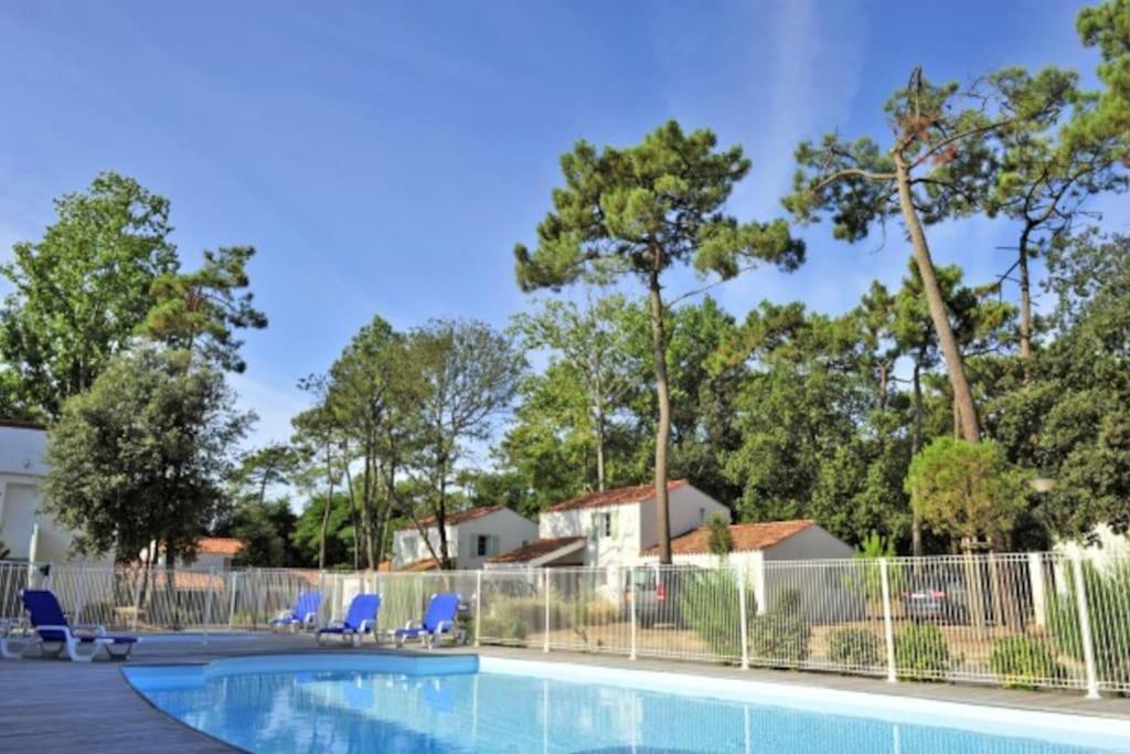 una piscina con sillas, una valla y árboles en Teïva, en Longeville-sur-Mer