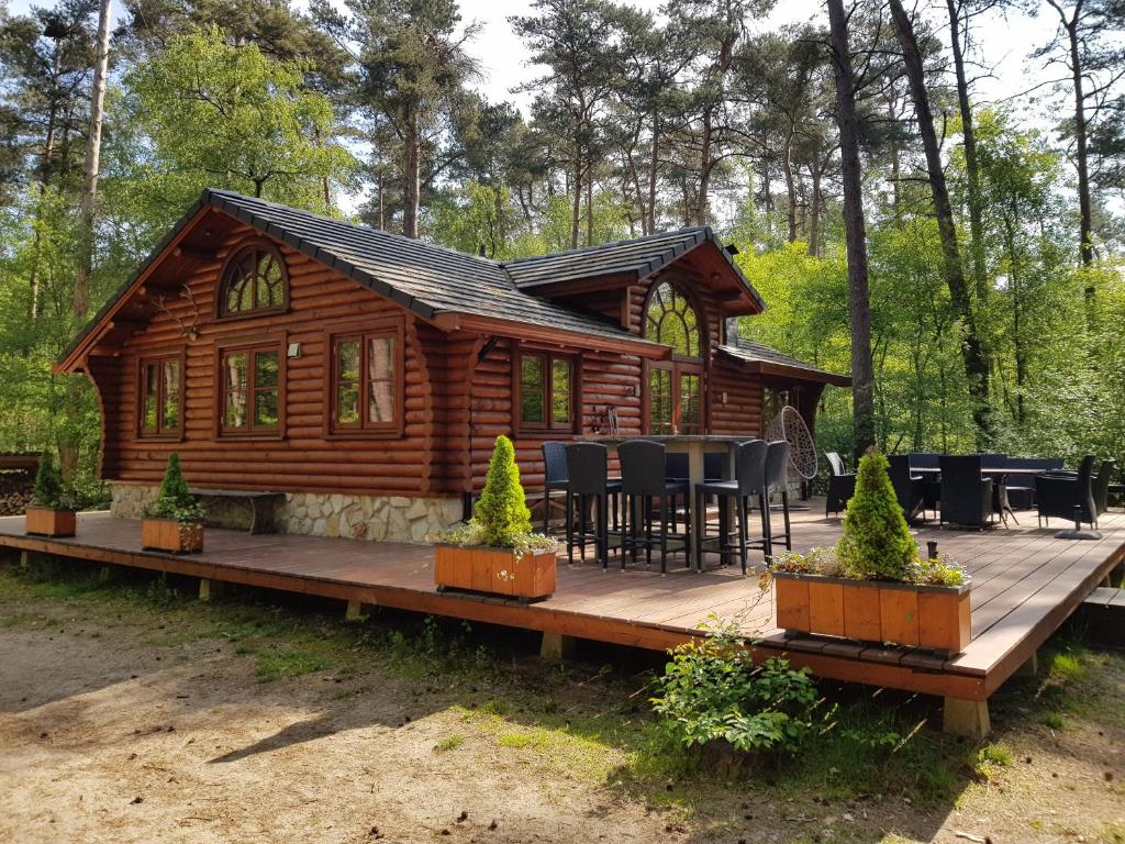 a cabin in the woods with a wooden deck at Lutterlodge in De Lutte