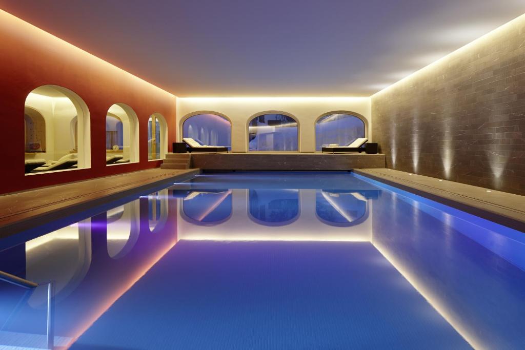 a swimming pool with blue water in a building at Hotel Steffani in St. Moritz