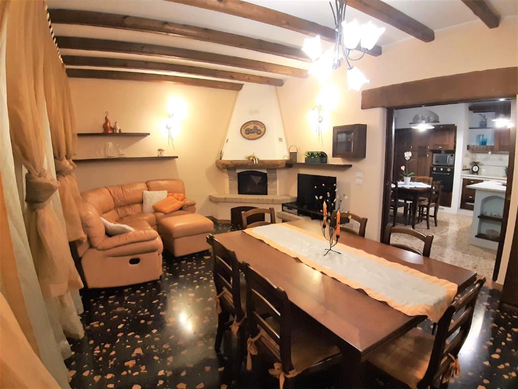 uma sala de estar com uma mesa e uma sala de estar com um sofá em GIOIA NELLE SELVE Family House - Casa Vacanze em Mogliano Veneto