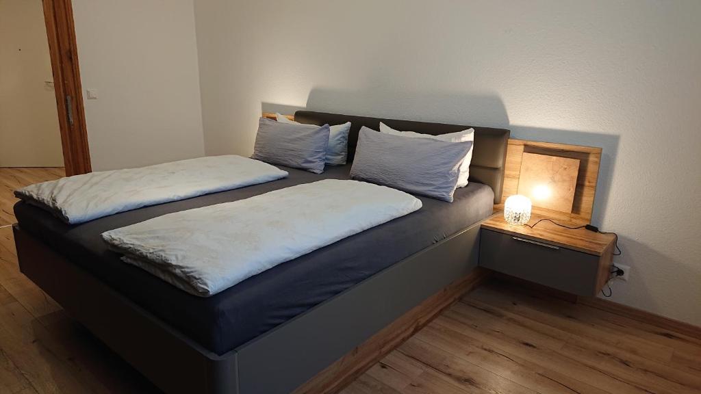 ein Schlafzimmer mit 2 Betten und einem Nachttisch mit einer Lampe in der Unterkunft Ferienwohnung zur Silbertanne in Ilsenburg