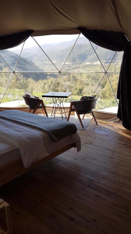 a bedroom with a bed and a table in a tent at DENGEKORU Natural Life & Glamping in Mudurnu