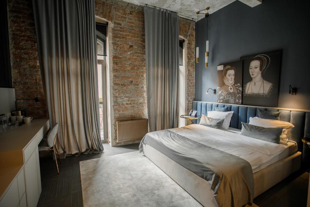 1 dormitorio con cama y pared de ladrillo en Victoria Deluxe Hotel en Chernivtsi
