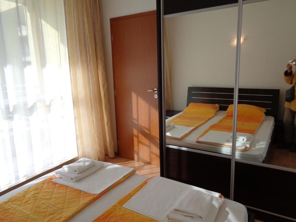 a bedroom with two beds and a large mirror at Apartment N4 in Sunset Beach 2,Слънчев бряг in Sunny Beach
