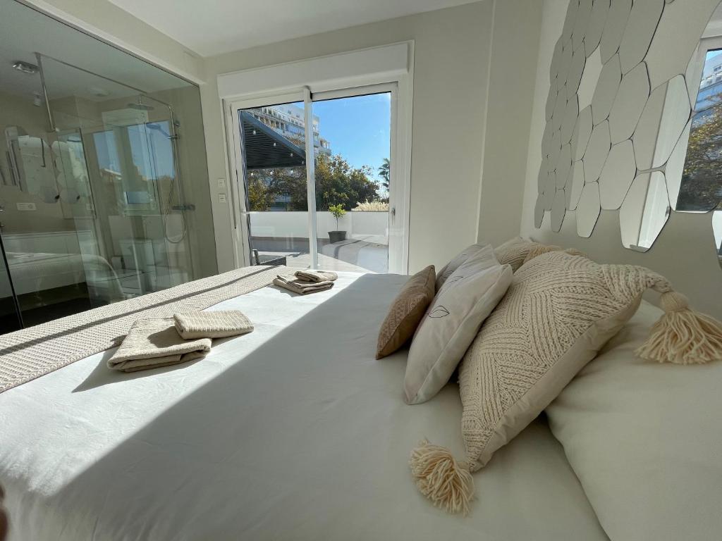 a large white bed with two pillows and a window at Marbella Centre with terrace and pool in Marbella