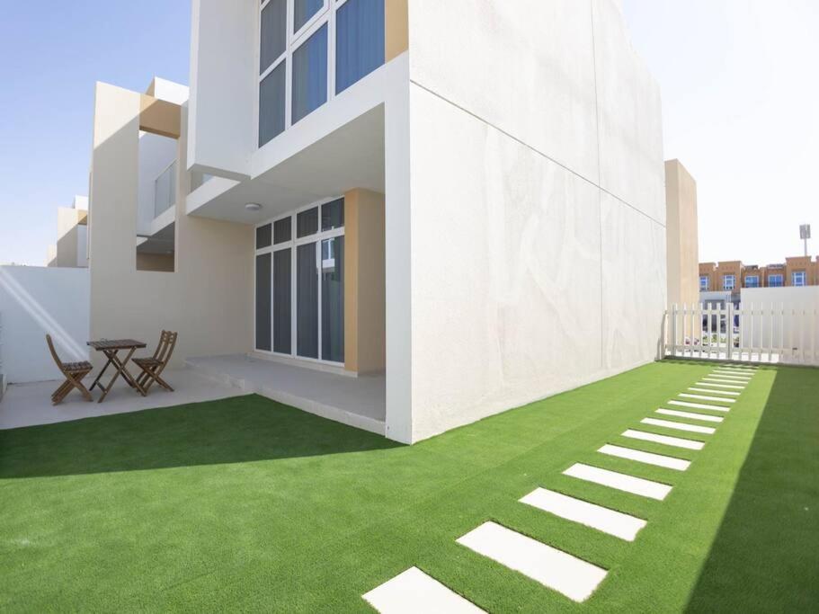 a rendering of a house with a green lawn at Brand new luxury 3bedroom villa in Damac Hills 2 in Dubai