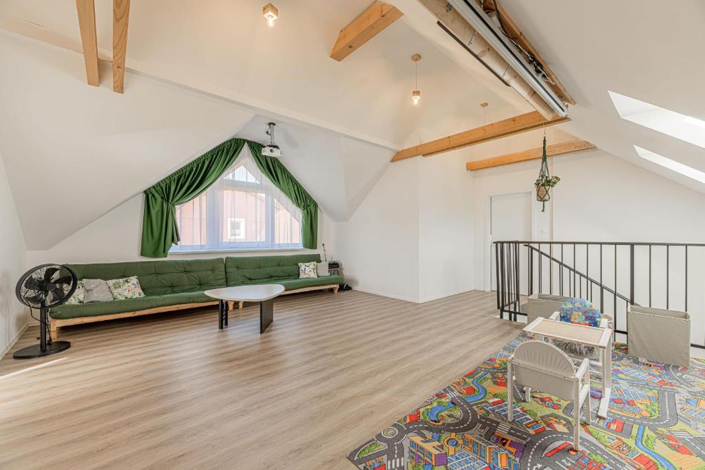 ein Wohnzimmer mit einem grünen Sofa und einem Fenster in der Unterkunft Chata Zdiarka 4M in Ždiar