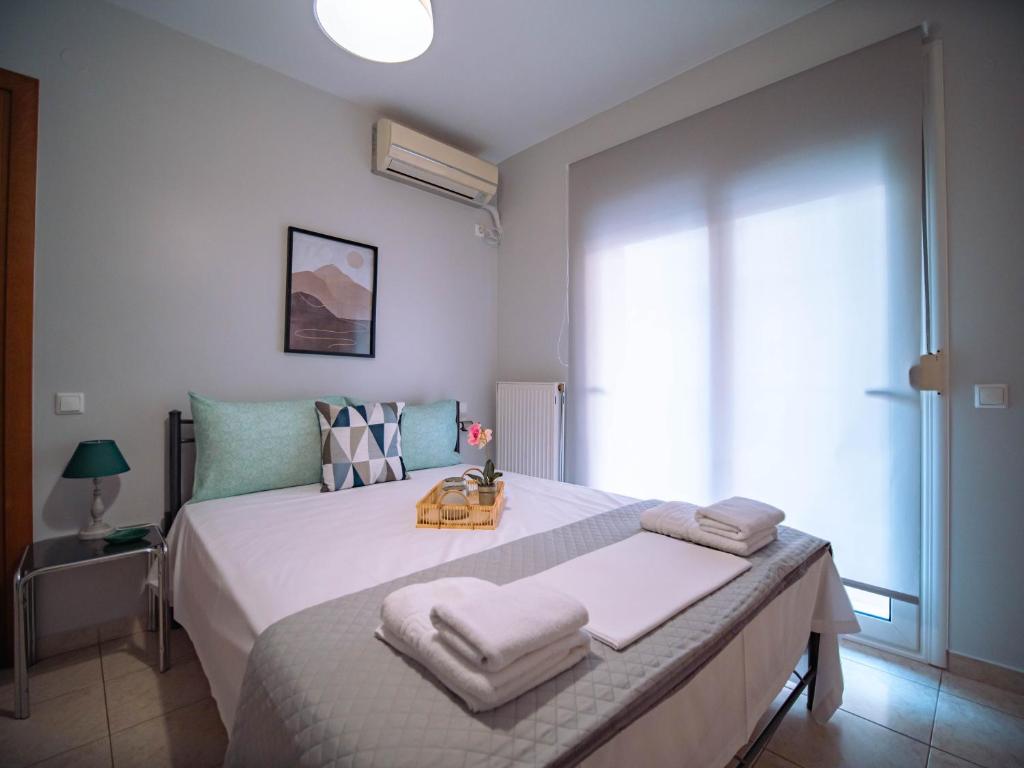 1 dormitorio con 1 cama grande y toallas. en Little Emerald - Central Spot Apartments en Volos