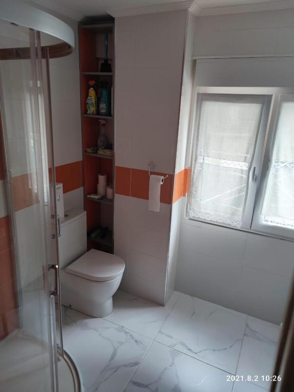 łazienka z toaletą i oknem w obiekcie Apartamento Zona Playa y centro Ciudad w mieście Santander