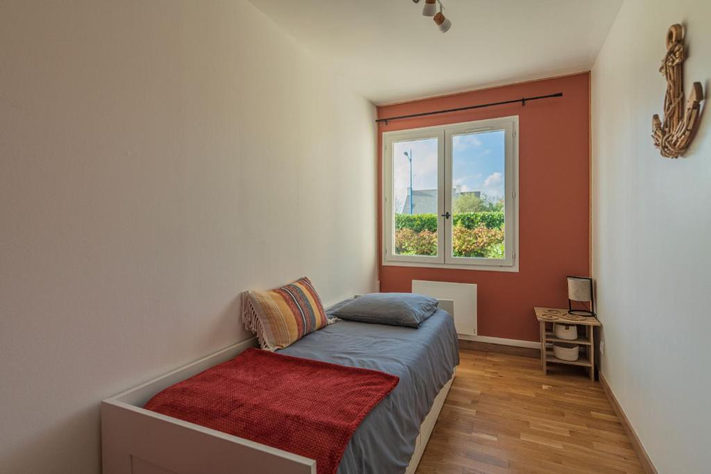 um pequeno quarto com uma cama e uma janela em Belle maison rénovée, 5mn à pied de la mer, classée meublé de tourisme 3 étoiles em Île-Tudy