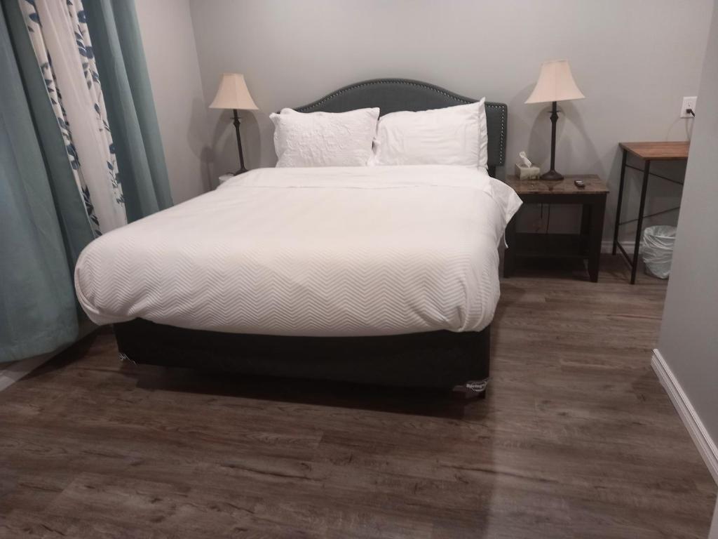 Una cama con sábanas blancas y almohadas en un dormitorio en Splendid Place en Kingston