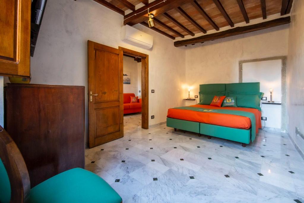 - une chambre avec un lit orange et vert dans l'établissement IBibiena - SUITE DEL CARDINALE, à Bibbiena
