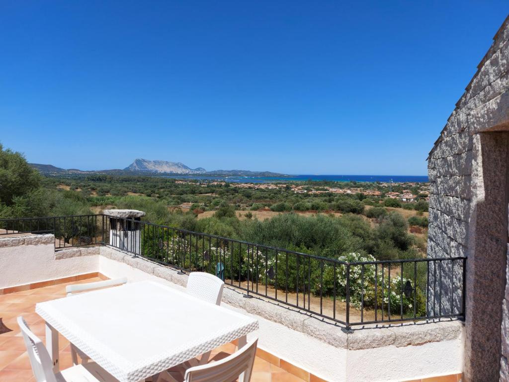 uma vista a partir da varanda de uma casa com uma mesa e cadeiras em Stazzo vista mare em San Teodoro