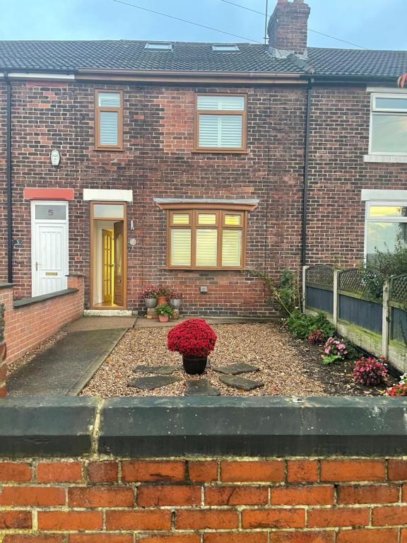 a brick house with a flower pot in the front yard at Green Villa in Hickleton