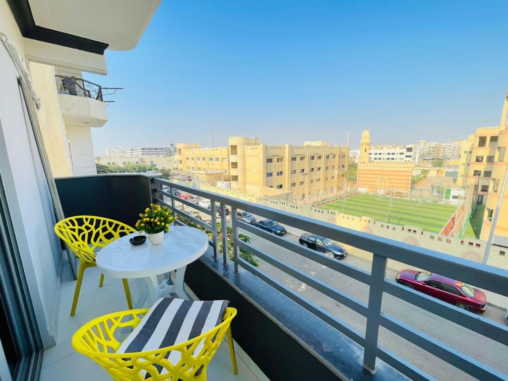 a balcony with a table and chairs and a view of a city at Studio House 589-1 in 6th Of October