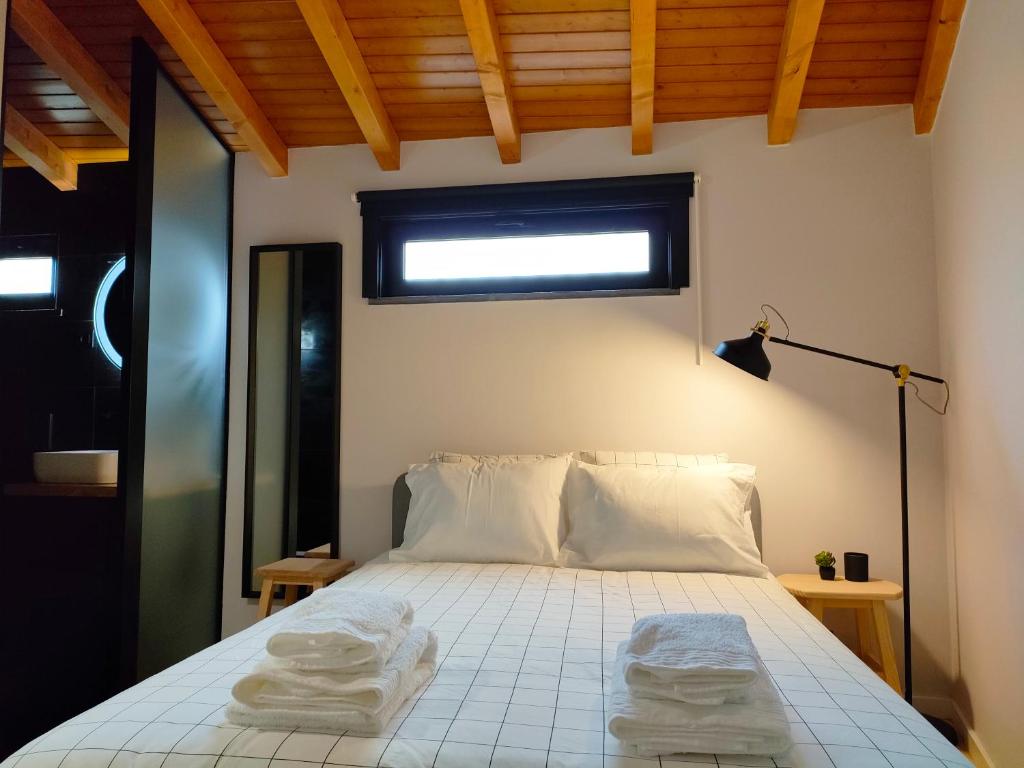 a bedroom with a bed with two towels on it at Casa d´ Avó Glória in Alvoco das Várzeas