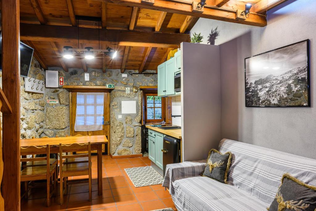 cocina y sala de estar con sofá y mesa en Casa do Tio Ferreiro, en Sabugueiro