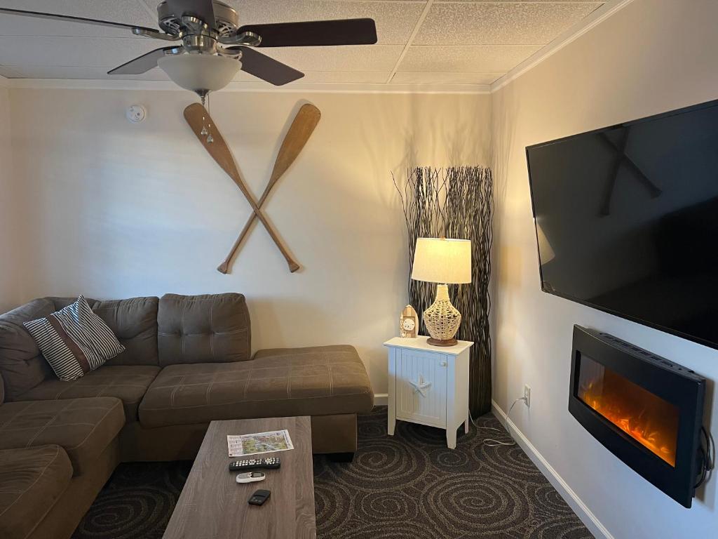 uma sala de estar com um sofá e um grande relógio na parede em Carbone's Beachside Guest Rooms em Sylvan Beach