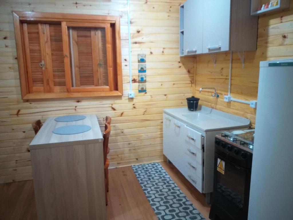 una piccola cucina con piano cottura e frigorifero di Haus Berg a São Francisco de Paula