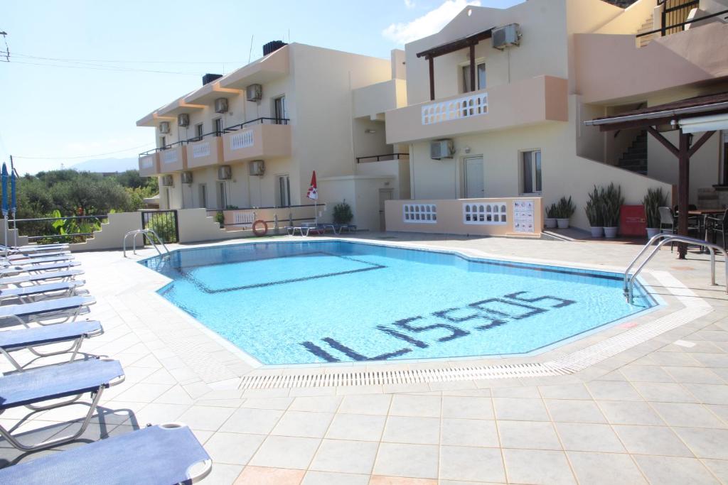 a swimming pool in front of a hotel at ilissos Apartments in Stalida