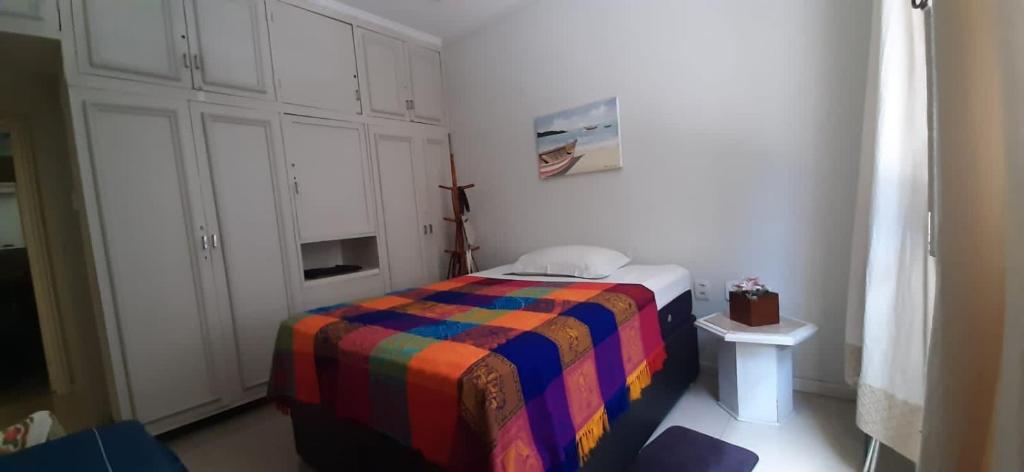 1 dormitorio con 1 cama con una manta colorida en Top quadra da praia Copacabana, en Río de Janeiro