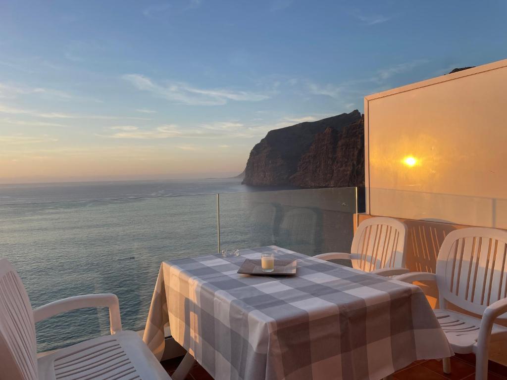 a table and chairs with a view of the ocean at Los Gigantes in front of Sea in Acantilado de los Gigantes