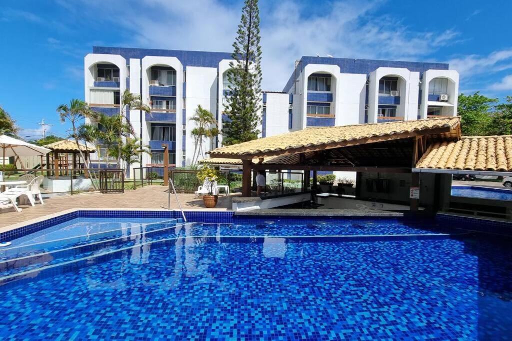 una gran piscina frente a un edificio en Apartamento próximo à praia, en Lauro de Freitas