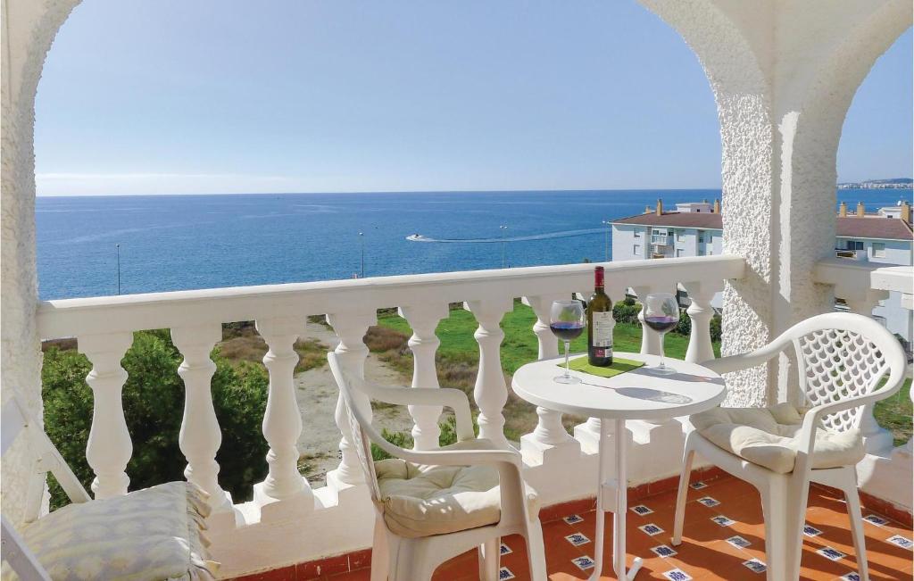 balcone con tavolo, sedie e vista sull'oceano di Beautiful Apartment In Mezquitilla With Kitchen a Mezquitilla