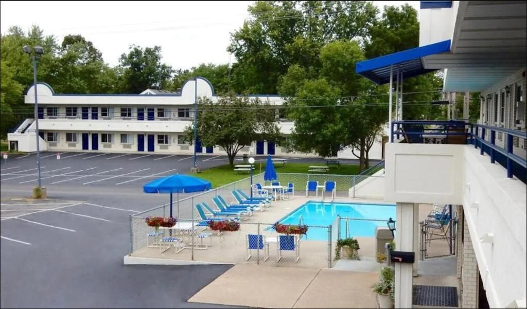 a pool with chairs and umbrellas in a parking lot at Fields Park Motel in Wisconsin Dells