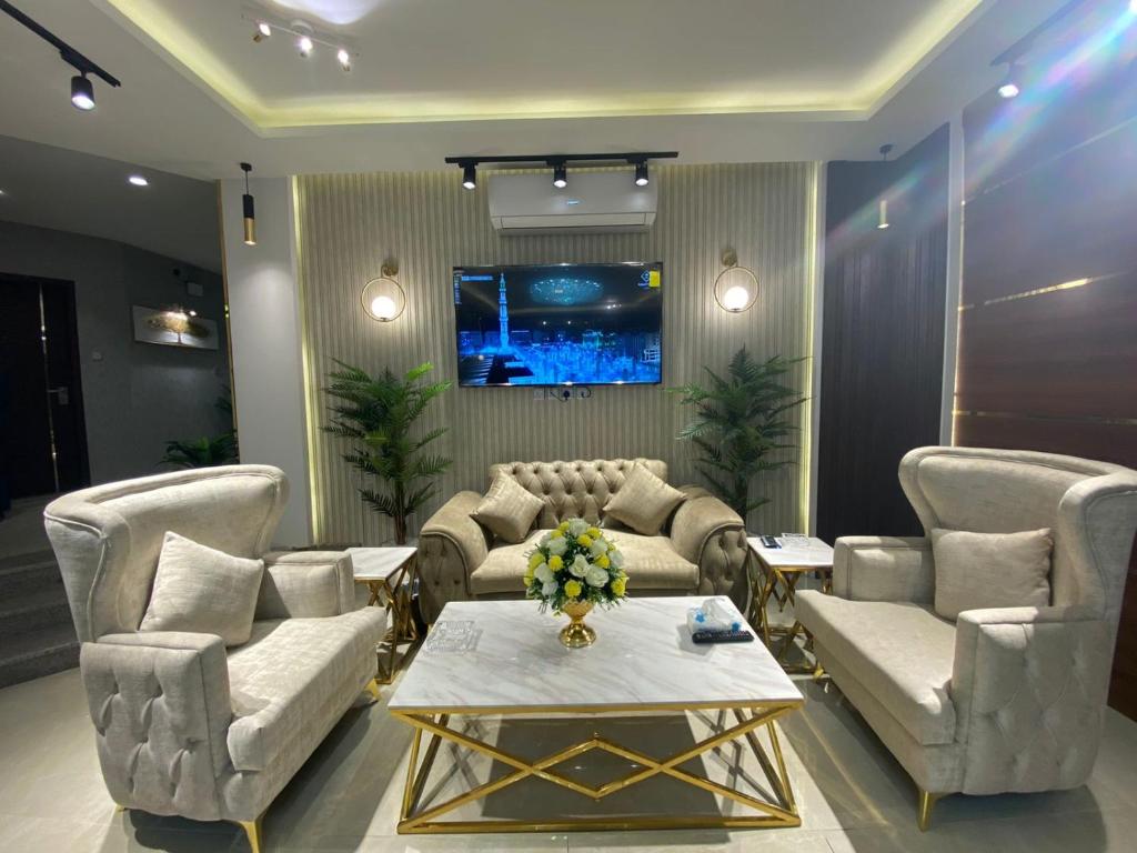 a living room with a couch and chairs and a table at شقق رويال العلا الفندقية in AlUla