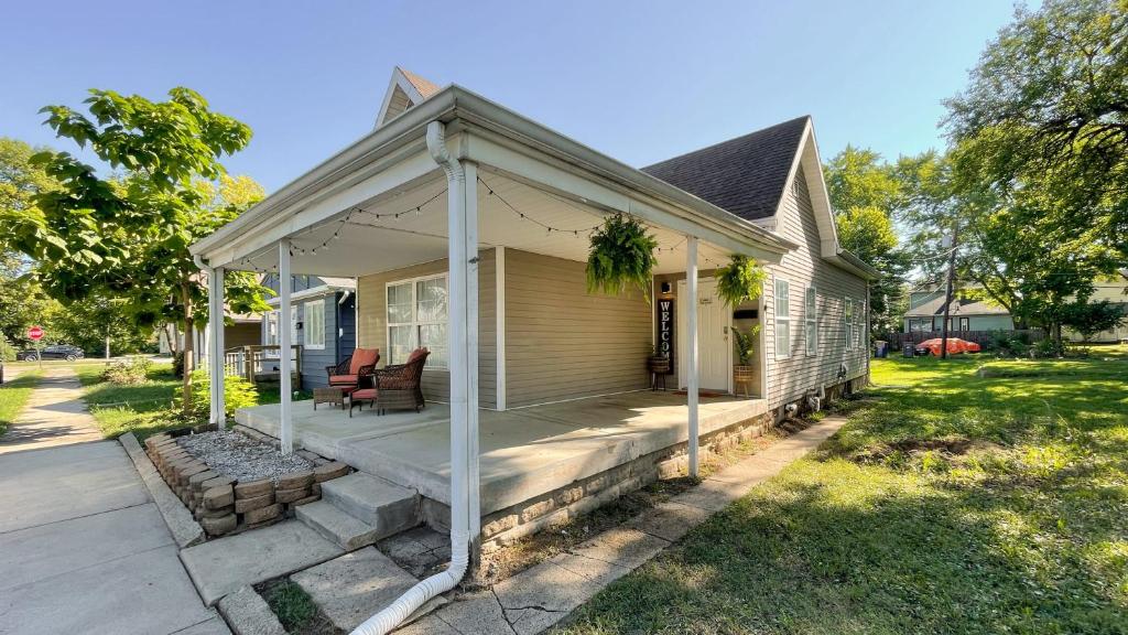 a house with a porch with two chairs on it at 5 mins to Speedway! Walk to Zoo, WR park, IUPUI! in Indianapolis