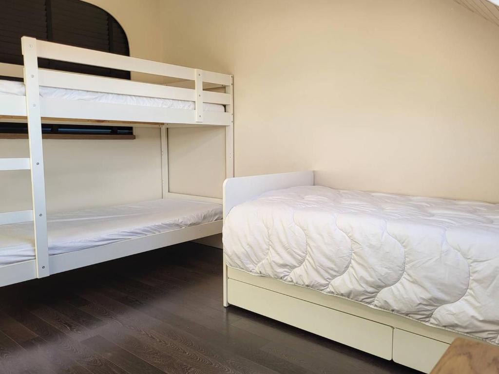 a bedroom with two bunk beds with white sheets at Appartement Merville-Franceville-Plage, 3 pièces, 6 personnes - FR-1-465-87 in Merville-Franceville-Plage
