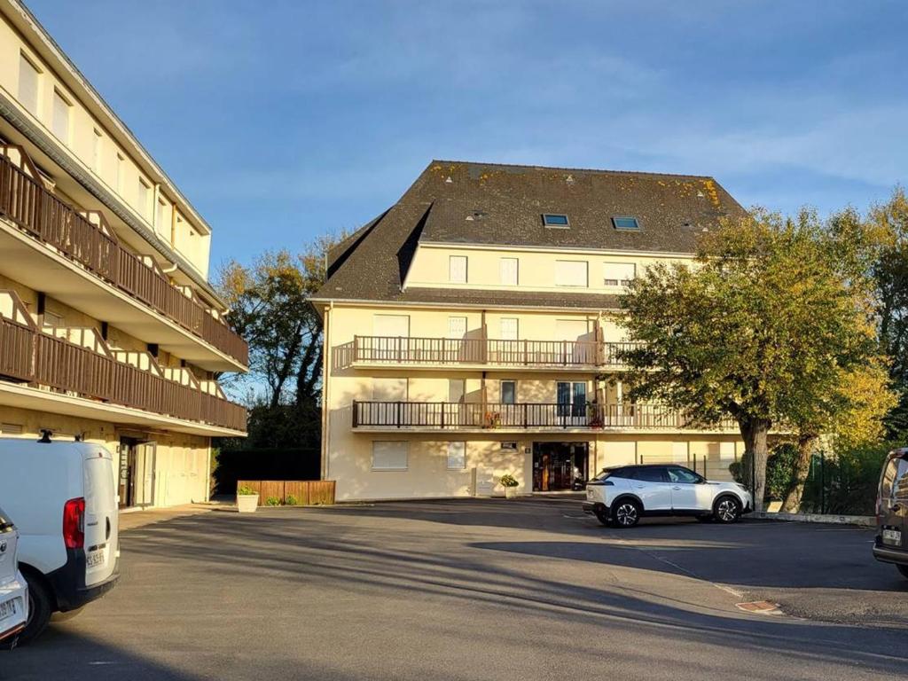 a white car parked in front of a large building at Appartement Merville-Franceville-Plage, 3 pièces, 6 personnes - FR-1-465-87 in Merville-Franceville-Plage