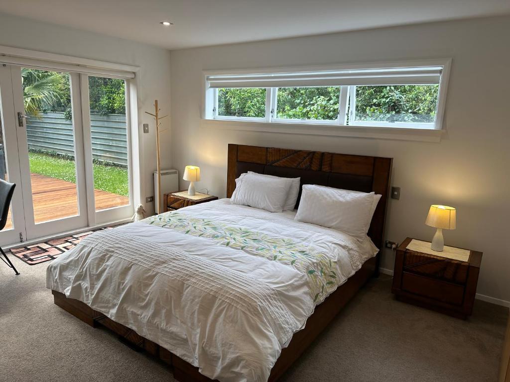 1 dormitorio con 1 cama grande y 2 ventanas en The perfect getaway for two in a large suite en Whanganui