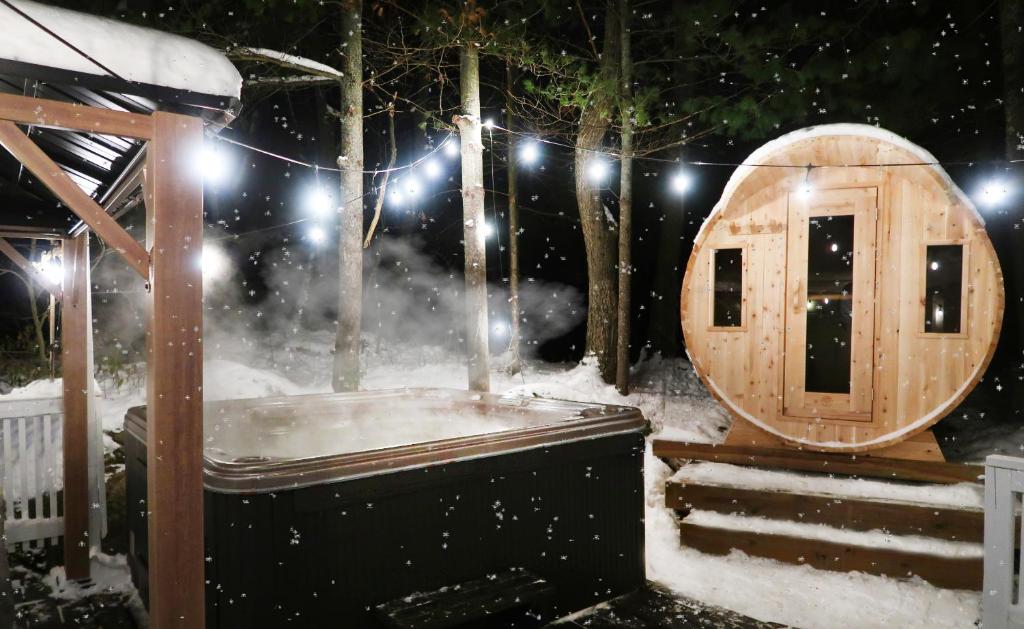 a wooden sauna in the snow in a yard at Winter Escape Waterfront Cottage Hottub&sauna! in Gravenhurst