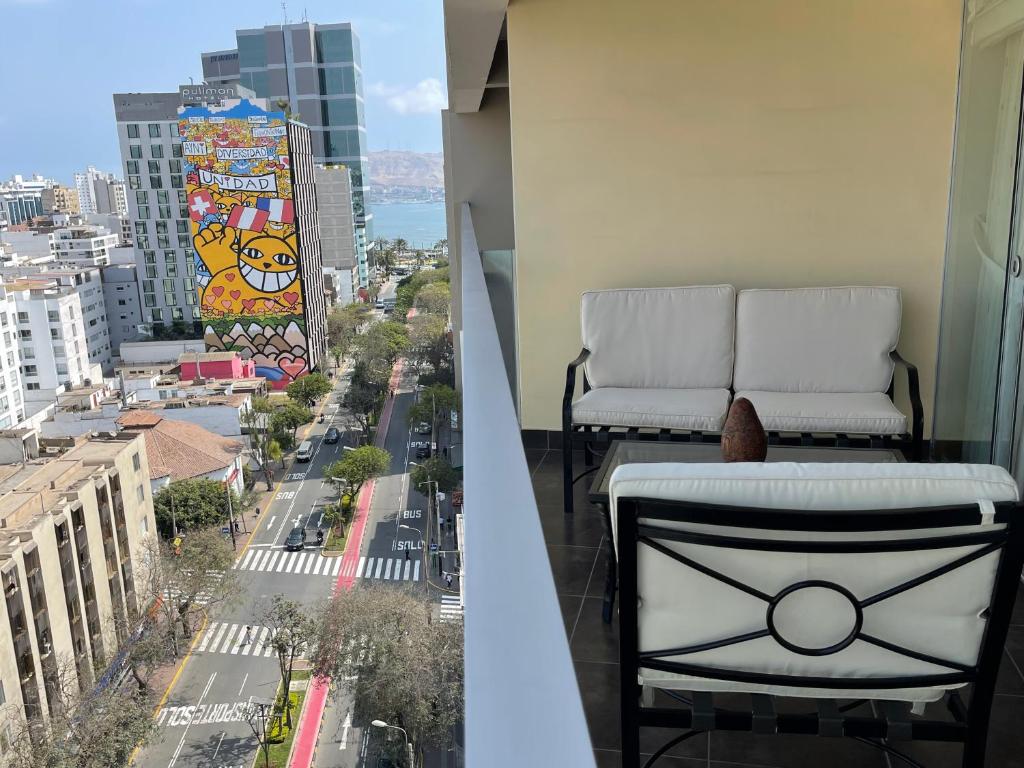 two chairs on a balcony with a view of a city at Book in Miraflores - Lima in Lima