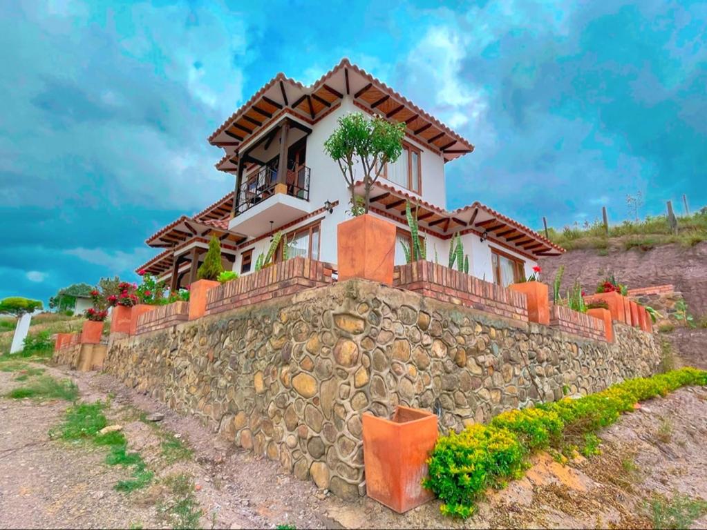 a house on top of a stone wall at Cabañas Duna Campestre in Sáchica