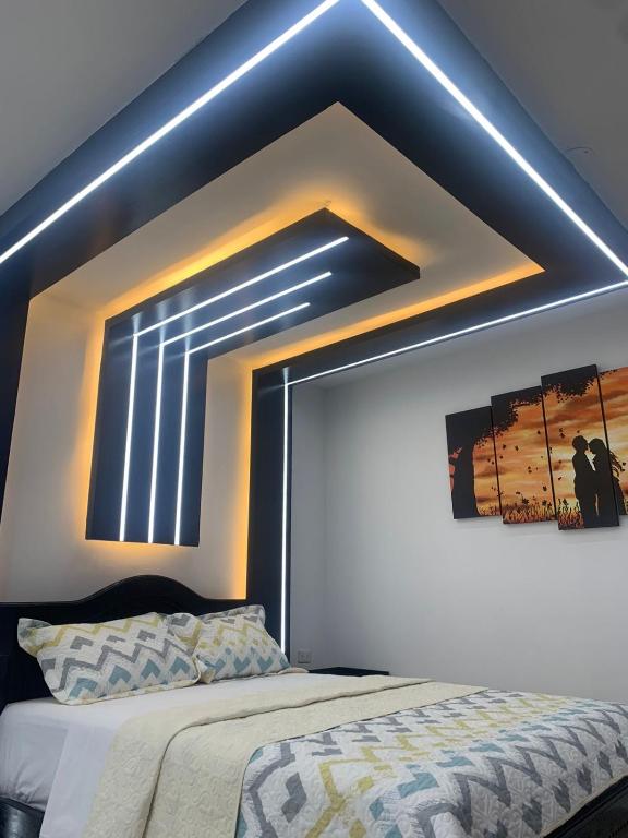 1 dormitorio con 1 cama con techo azul en Hotel Monaco, en Santo Domingo de los Colorados