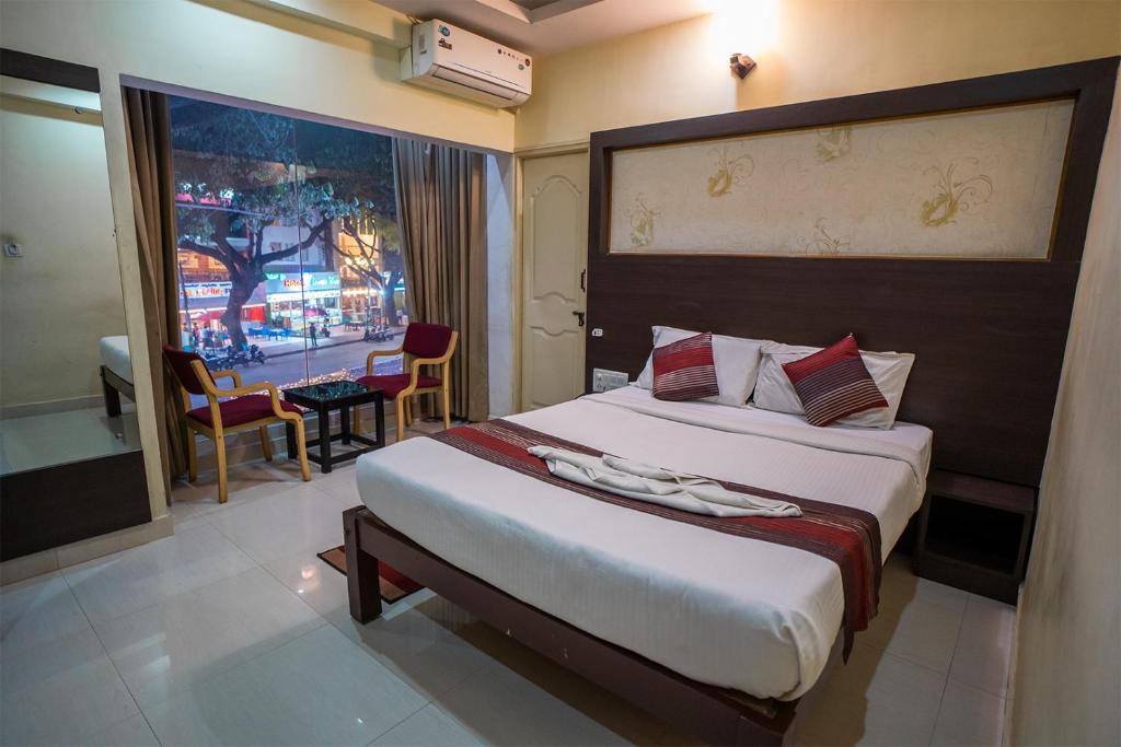 a hotel room with a large bed and a window at HOTEL PRAKAASH COMFORTS in Vānivilāsa Puram