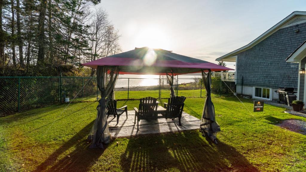 einen Pavillon mit Stühlen darunter im Hof in der Unterkunft Sunset Tides in Oak Haven