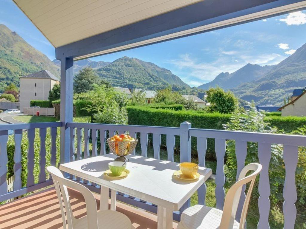 a white table and chairs on a balcony with mountains at Appartement Esquièze-Sère, 3 pièces, 6 personnes - FR-1-402-26 in Esquièze - Sère