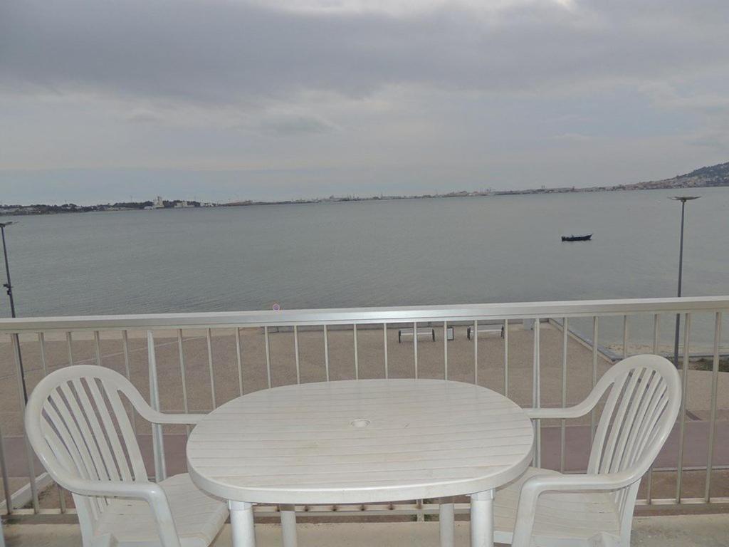 - une table et deux chaises sur un balcon avec eau dans l'établissement Agréable T1 proche établissement Thermal, animaux admis - FR-1-571-18, à Balaruc-les-Bains