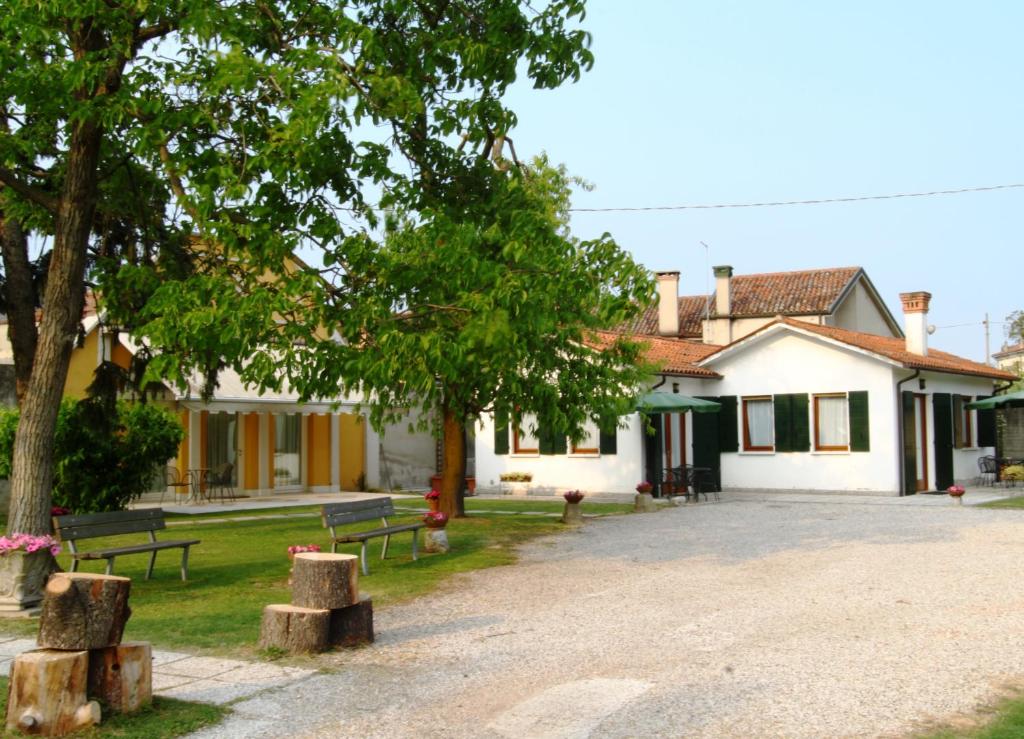 een huis met bomen en banken ervoor bij Villa Olanda in Mira