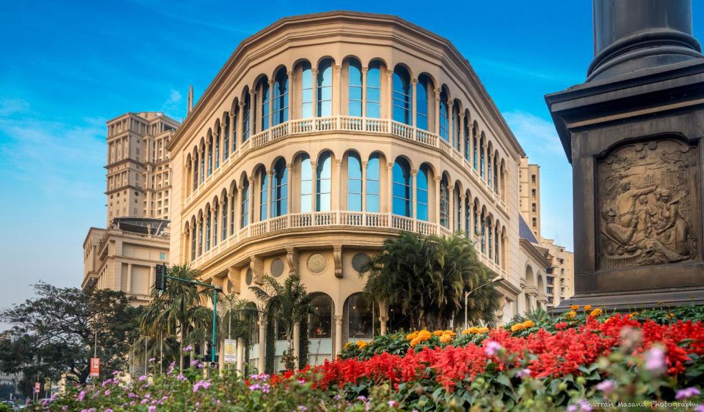 a large building with flowers in front of it at Rodas An Ecotel Hotel in Mumbai